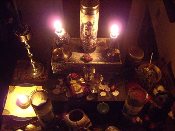degančios žvakės ir monetų amuletas sėkmei
